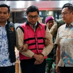 Andri Mulyono (tengah) digiring penyidik Kejaksaan Agung usai ditetapkan sebagai tersangka kasus dugaan korupsi pengadaan motor listrik Program Makan Bergizi Gratis (MBG)