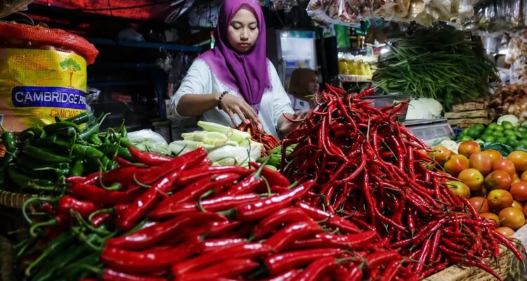 Pedagang menata cabai merah dan bahan pangan di pasar tradisional saat harga sejumlah komoditas mengalami kenaikan.