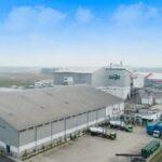 Kawasan industri di Kabupaten Serang dengan deretan pabrik, gudang, dan kendaraan logistik dari sudut udara.