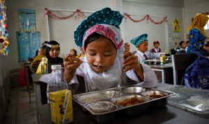 Mampukah Makan Bergizi Gratis Bertahan hingga 2030 Siswa sekolah menikmati Program Makan Bergizi Gratis sebagai upaya peningkatan kualitas sumber daya manusia Indonesia.