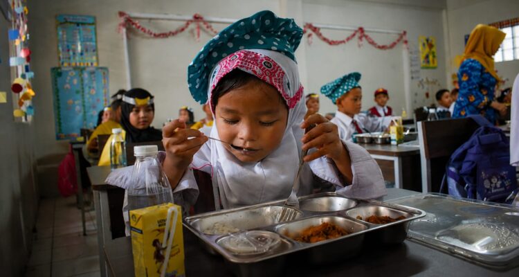 Siswa sekolah menikmati Program Makan Bergizi Gratis sebagai upaya peningkatan kualitas sumber daya manusia Indonesia.