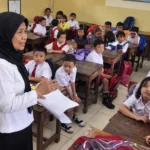 Guru mengajar siswa di ruang kelas