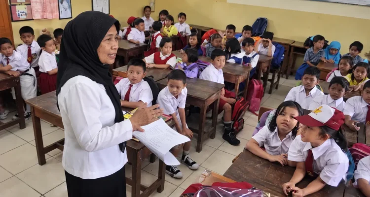 Guru mengajar siswa di ruang kelas