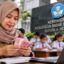 Ilustrasi guru menghitung uang terkait pencairan Tunjangan Profesi Guru non-ASN.