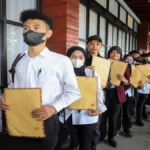 Anak muda pencari kerja membawa berkas saat mencari pekerjaan