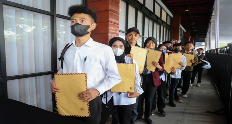 Anak muda pencari kerja membawa berkas saat mencari pekerjaan