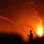 Kebakaran lahan dengan kobaran api dan asap tebal saat penanganan karhutla.